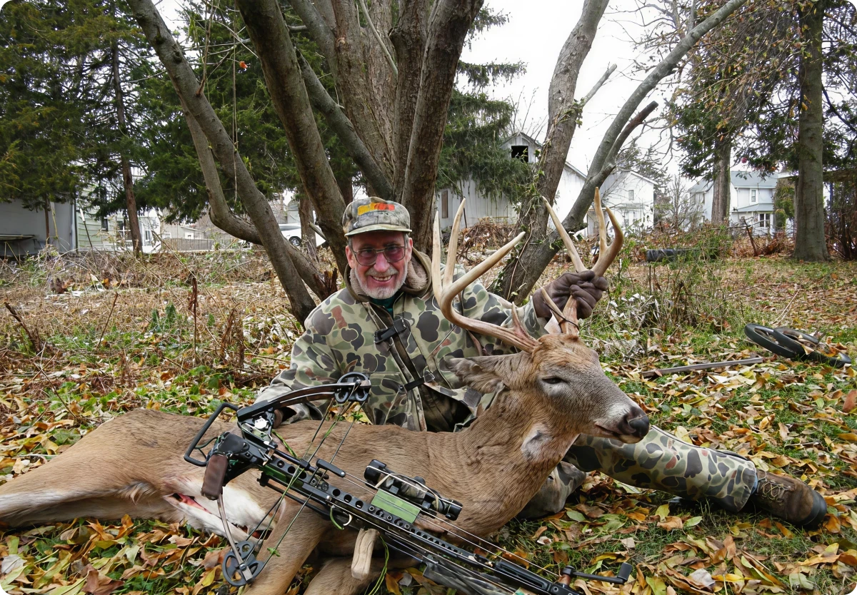 Man with deer and bow outdoors